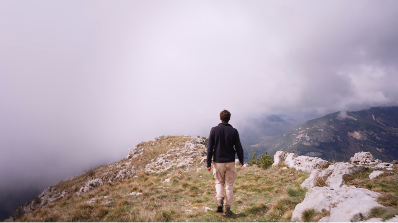 Marche sur une crête rocheuse dans les nuages